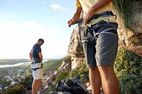 Two men putting on climbing equipment — Stock Photo, Image