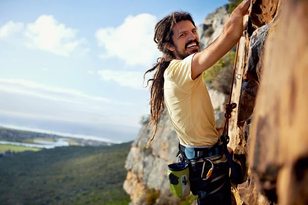 Rockclimbing człowiek z dredami uśmiechający się — Zdjęcie stockowe