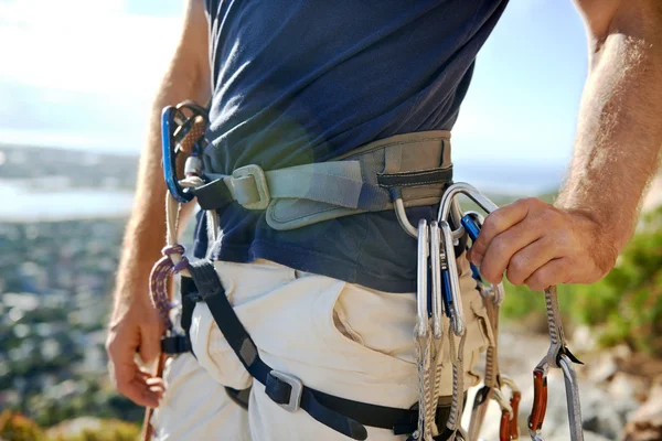 Homem em arnês e equipamento de escalada — Fotografia de Stock