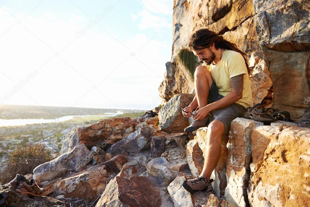 Hiker tying shoelaces on mountain
