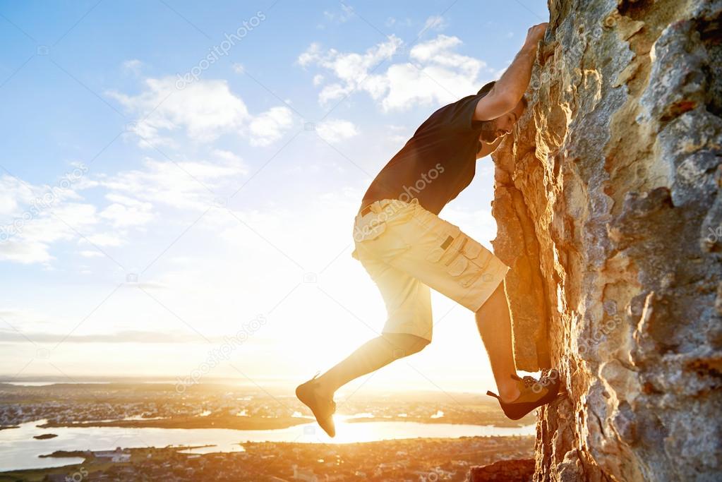 Man rockclimbing up steep mountain