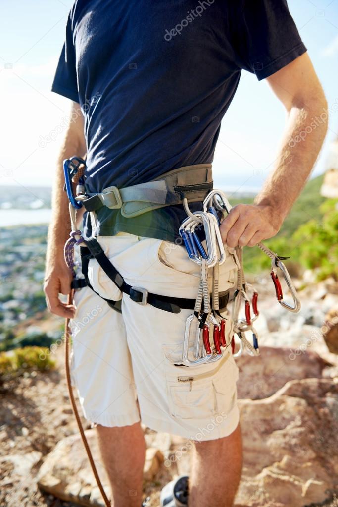 man in harness and rockclimbing equipment