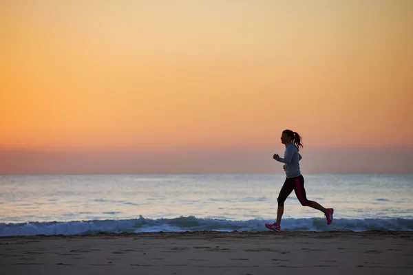 朝のビーチを走る女性 — ストック写真