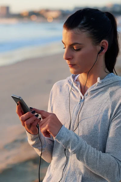 Donna che sceglie la musica per l'allenamento del mattino — Foto Stock