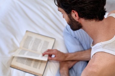 man on bed reading book