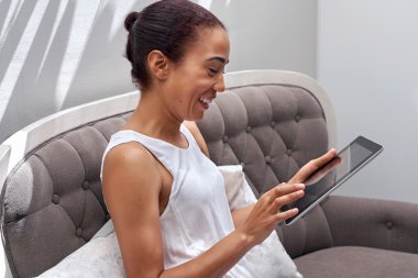 Kadın kanepe okuma tablet üzerinde rahatlatıcı
