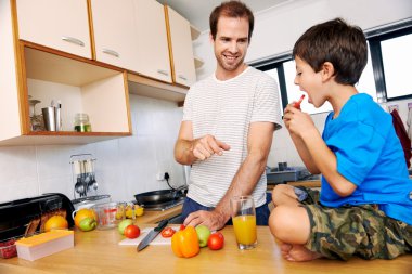 Babası yemek yapan çocuğu domates yiyor