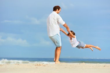 Baba ve kızı birlikte kumsalda oynarken