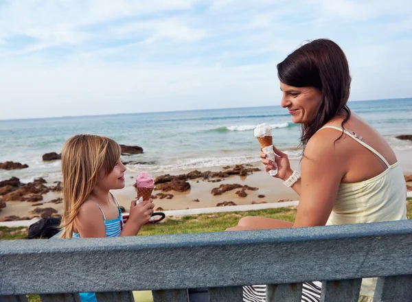 Mamma och dotter njuta av glass på stranden — Stockfoto