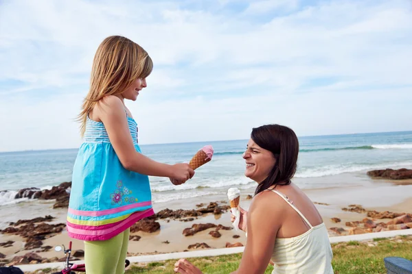 Mom and daughter enjoy ice cream at beach — Stock Photo, Image