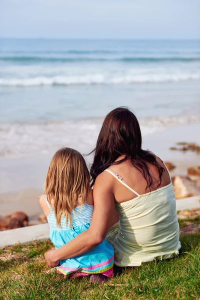 Mamma och dotter embracing på ocean — Stockfoto