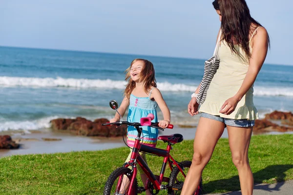 Ragazza figlia imparare ad andare in bicicletta in spiaggia — Foto Stock