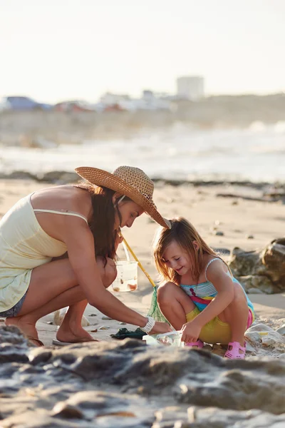 Mor och dotter fiske på stranden — Stockfoto