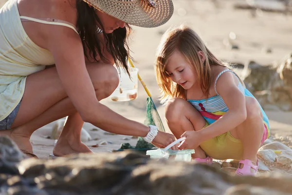 Mor och dotter fiske på stranden — Stockfoto