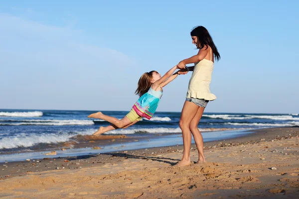 Speelse moeder en dochter op strand — Stockfoto