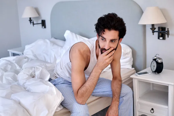 Homme assis sur le lit à la maison — Photo