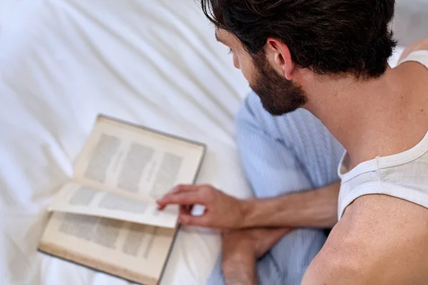 Man op bed lezen van boek — Stockfoto