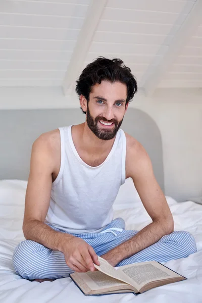 Man on bed reading book — Stock Photo, Image