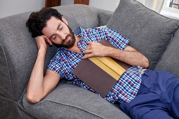 Ο άνθρωπος που κοιμάται στον καναπέ, διαβάζοντας το βιβλίο — Φωτογραφία Αρχείου
