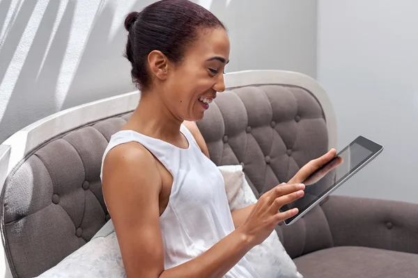 Frau entspannt sich auf Sofa und liest Tablet — Stockfoto