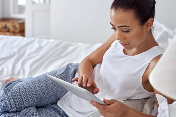 Vrouw ontspannen op bed met Tablet PC — Stockfoto