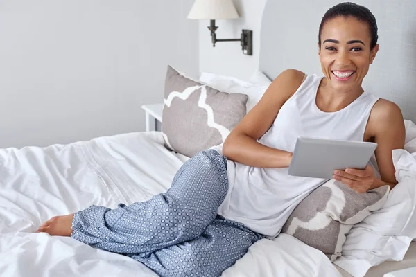 Mulher relaxante na cama com tablet — Fotografia de Stock