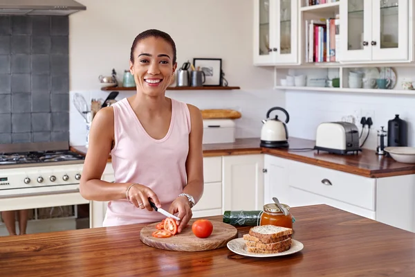 Nainen tekee tomaatti voileipä — kuvapankkivalokuva
