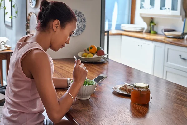 Vrouw genieten van salade met cellphone — Stockfoto