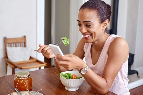 Mulher gostando de salada com celular — Fotografia de Stock