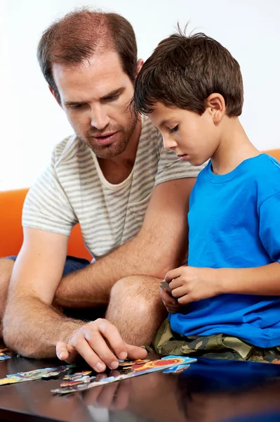 Отец помогает сыну с головоломкой — стоковое фото