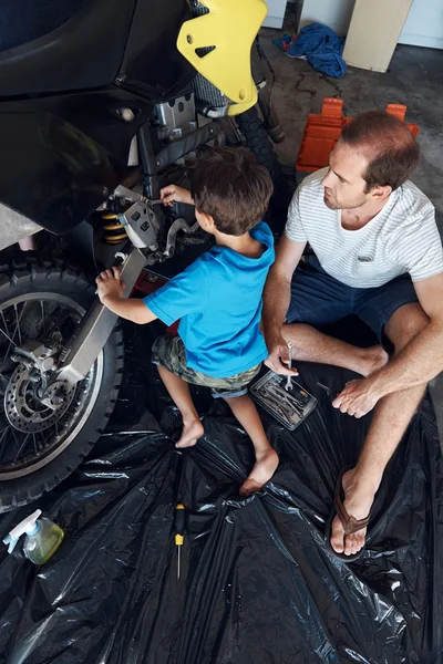 Fatehr och son limning över fastställande motorcykel — Stockfoto