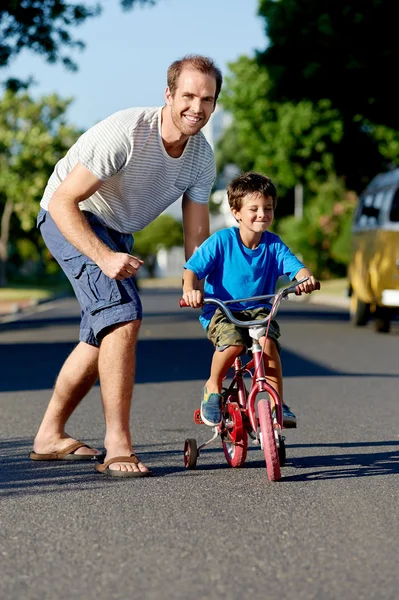 Vader onderwijs zoon leren rijden fiets — Stockfoto