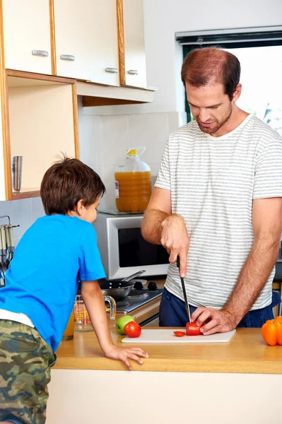 Papá picando tomate en la cocina — Foto de Stock