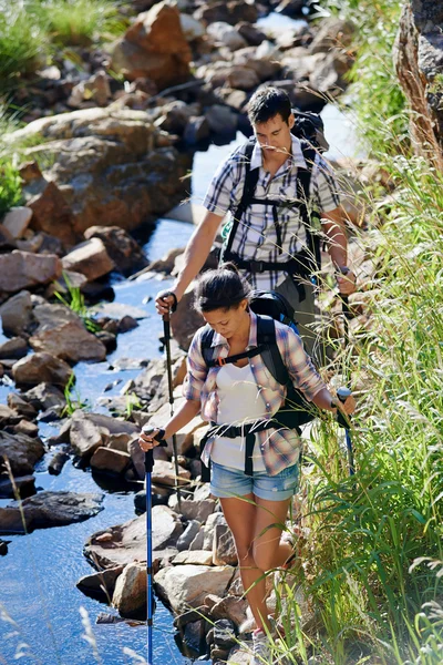 Paar backpacken langs stream — Stockfoto