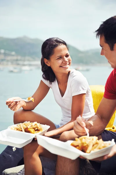 Mujer y pareja comer pescado y patatas fritas — Foto de Stock