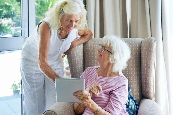 Alte Freunde blicken auf einen Touchscreen — Stockfoto