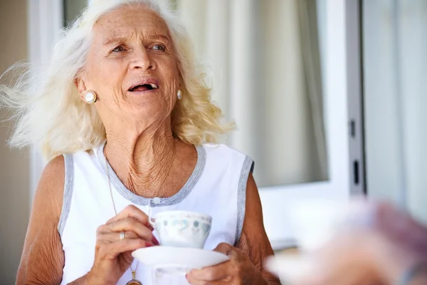 Oude dame houden Thee beker — Stockfoto