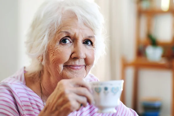 Starsza pani trzyma kubek herbaty — Zdjęcie stockowe