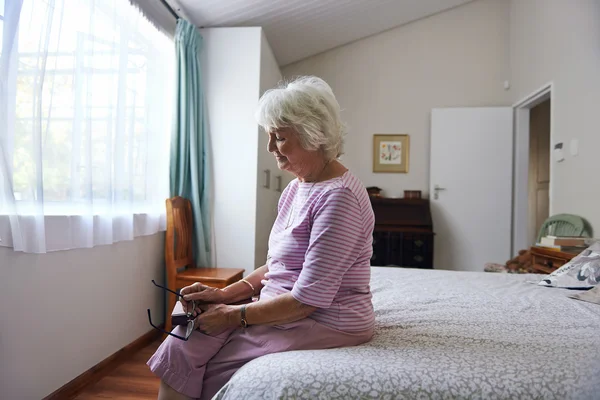 Witwe sitzt auf Bett und sieht traurig aus — Stockfoto