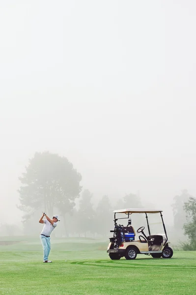 Golfista em fairway com carrinho — Fotografia de Stock