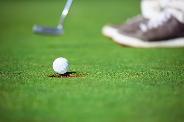Bola de golfe caindo em buraco — Fotografia de Stock