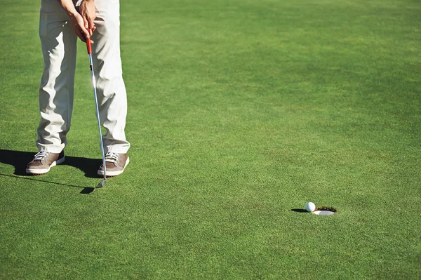 Golf uomo con l'obiettivo di affondare golf putt — Foto Stock
