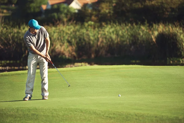 Golf hombre con el objetivo de hundir golf putt — Foto de Stock