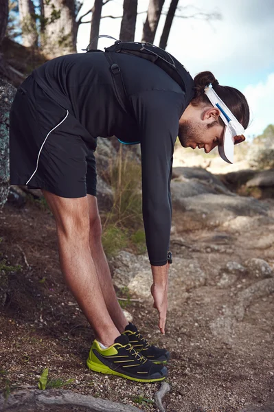 Trail runner stretching before running — Stock Photo, Image