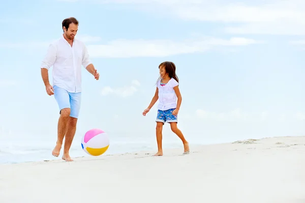 Far och dotter springer på stranden — Stockfoto