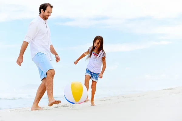 Far och dotter springer på stranden — Stockfoto