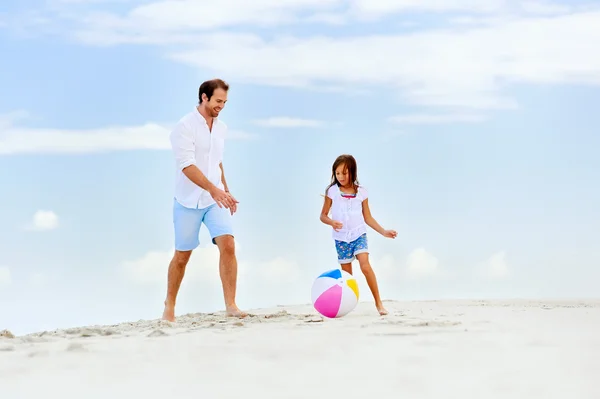 Vader en dochter lopen op het strand — Stockfoto