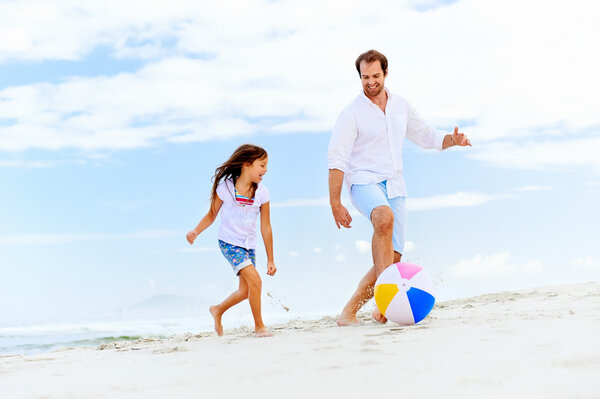 father and daughter running on beach