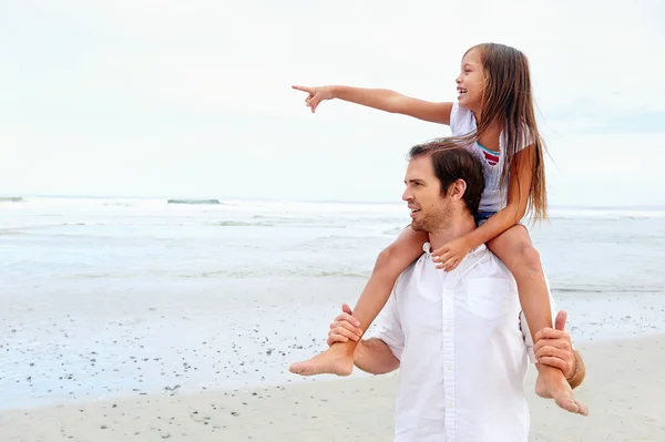Daughter on dad at beach — Stock Photo, Image