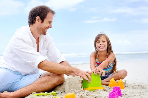 Father and daughter building sand castle — Stock Photo, Image